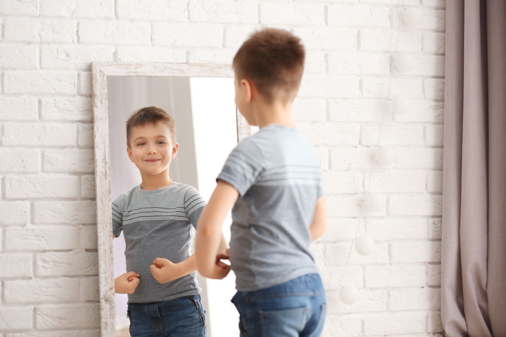 Cute Little Boy Posing in Front of a Mirror Indoors